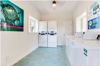a laundry room with two white washers and a washer and dryer  at The Oasis on Cascade, Atlanta, GA